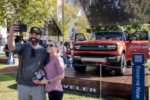 George Workman and Jessica Bayer take a picture with the new Scout Motors Traveler SUV, displayed at Williams-Brice Stadium before USC’s matchup with Missouri on November 16, 2024. (Tracy Glantz)