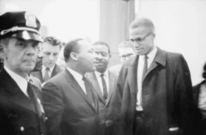 Martin Luther King Jr. and Malcolm X wait for a press conference to begin – March 26, 1964 (Photo: Library of Congress/Marion S.)